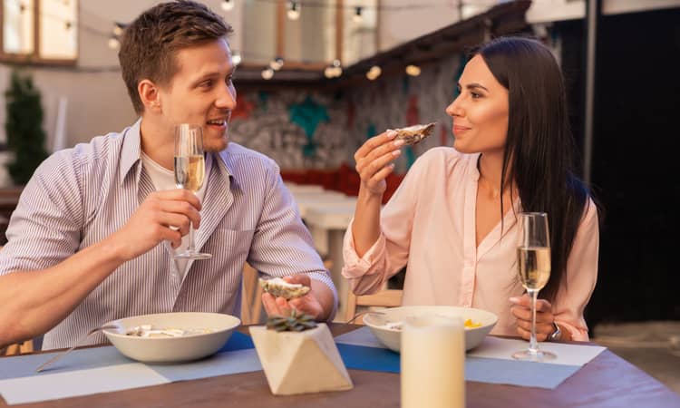 Two people having oysters and champagne 