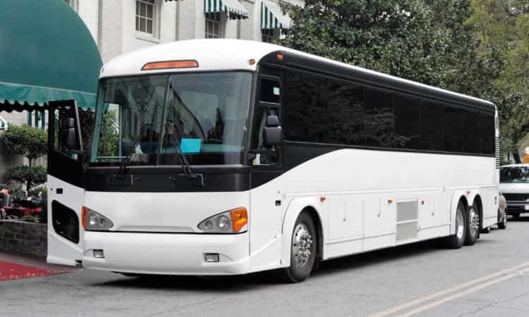 full sized charter bus parked in front of a building