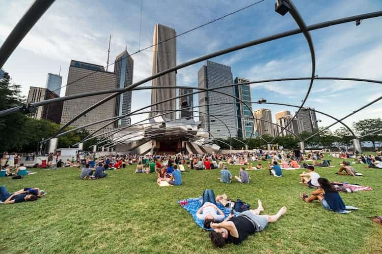 visitors lay in the grass at chicago's millennium park