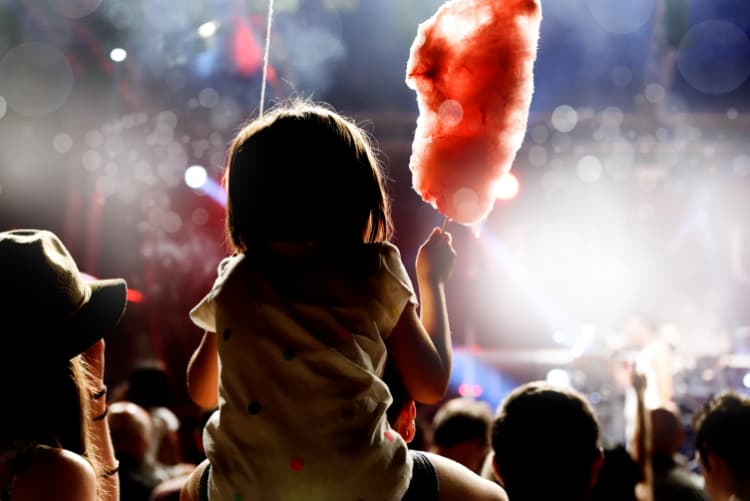 A silhouette of a child watching a concert