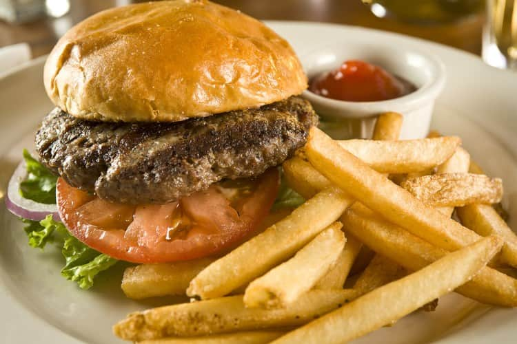 A hamburger and fries with ketchup at a theme park