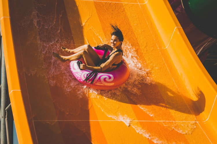 a girl plunges down a waterslide in a tube at Elitch Gardens in Denver