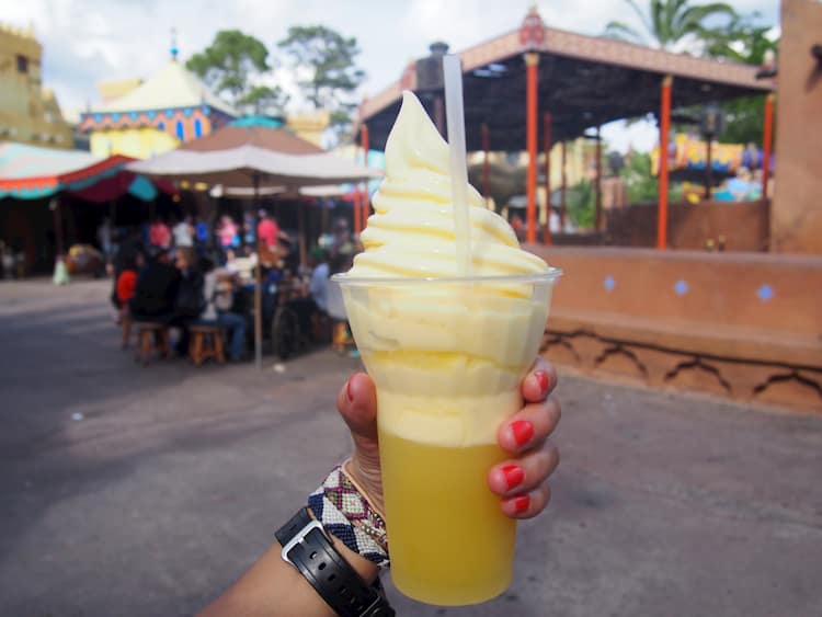Person's hand holding up Dole Whip at Magic Kingdom