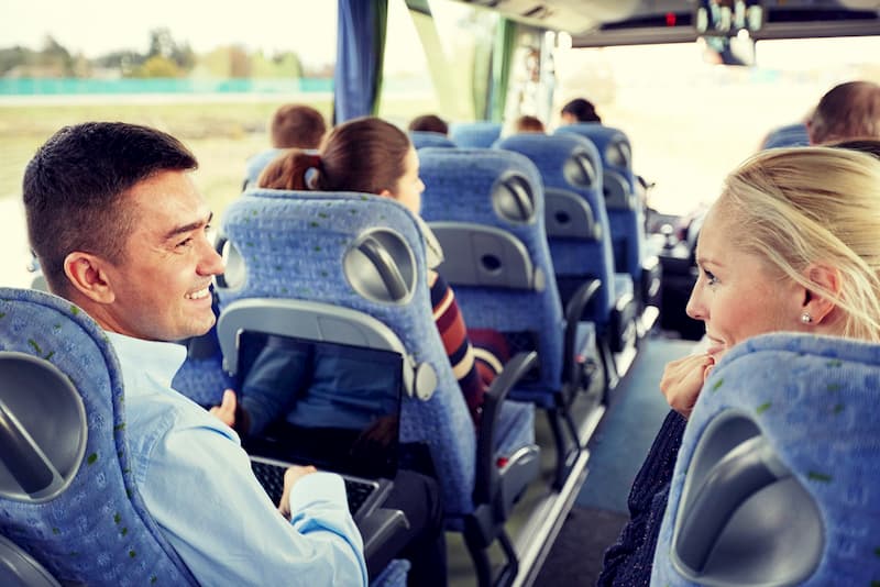 professionals traveling on a charter bus and using a computer while in transit