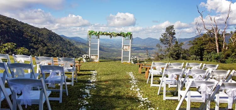 an altar and seats sit ready for a wedding ceremony with the mountains in the background