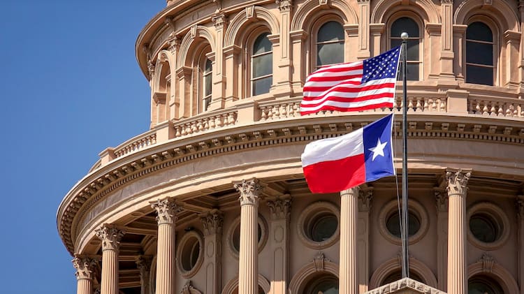 an american flag and a texas state flag fly over the capitol rotunda