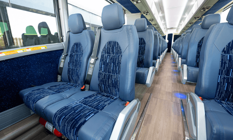 a row of seats with seat belts on a charter bus