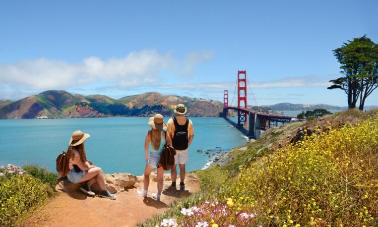 tourists looking at the golden gate bridge from a vista point