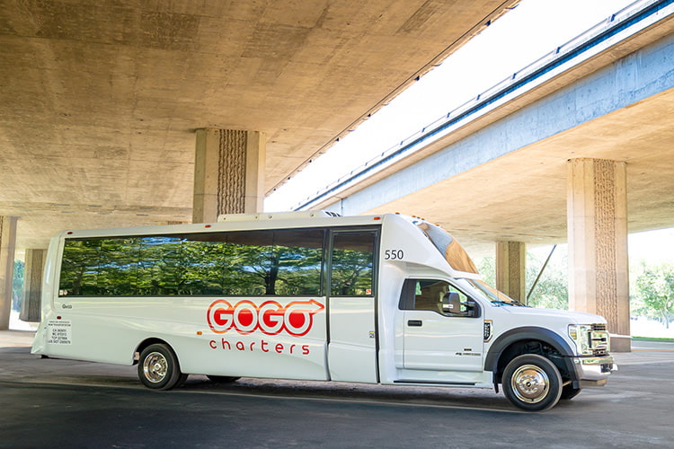 GOGO Charters branded minibus parked under an overpass