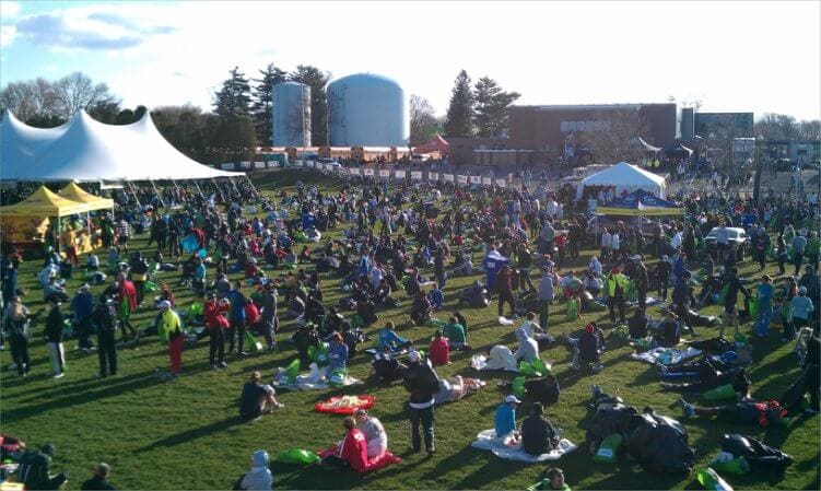 runners sit and relax at the boston marathon athletes' village