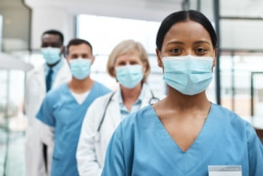 hospital workers wearing masks stand in a line