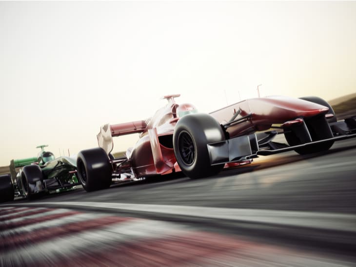 a racecar speeding down a track, slightly blurred