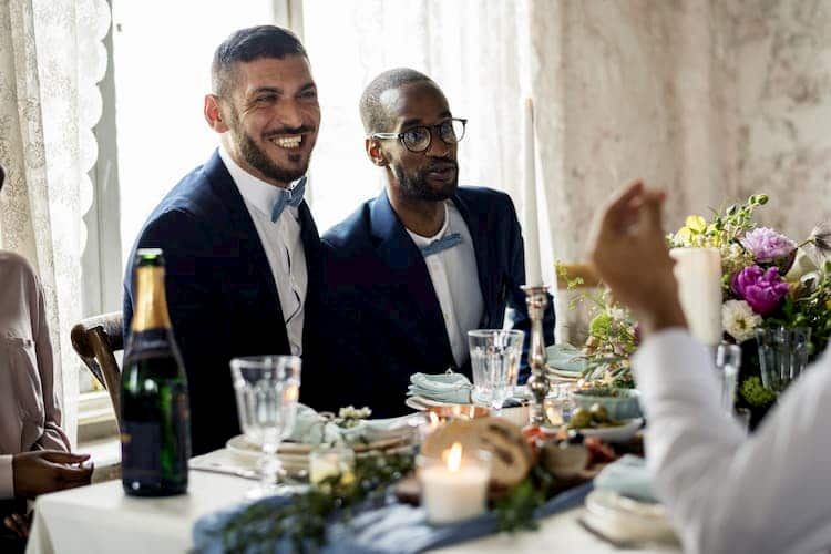 Two grooms at table at wedding reception