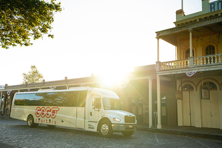 A minibus parked outside a venue at sunset.