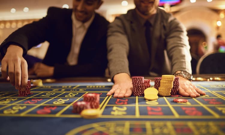 Two men placing chips on a poker table