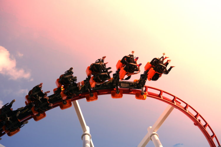 thrill-seekers on a roller coaster as it spirals into the sky