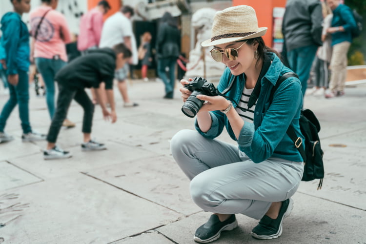 A tourist with a camera takes a photo of the ground outside the TCL Chinese Theatre