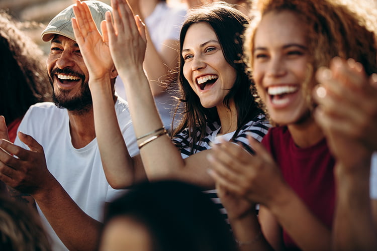 Concert attendees cheer and clap at a big event