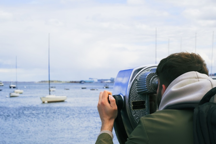 a tourist looks at boats on the water