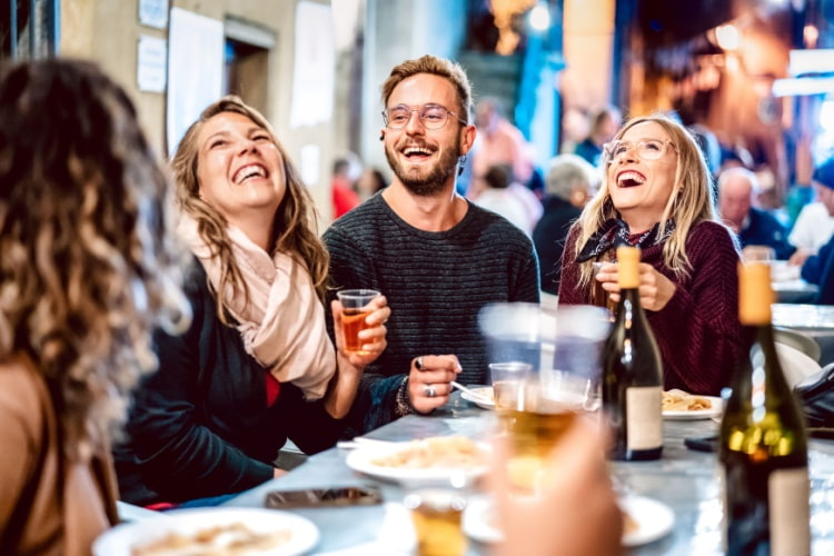 a group of friends laugh together at a food festival