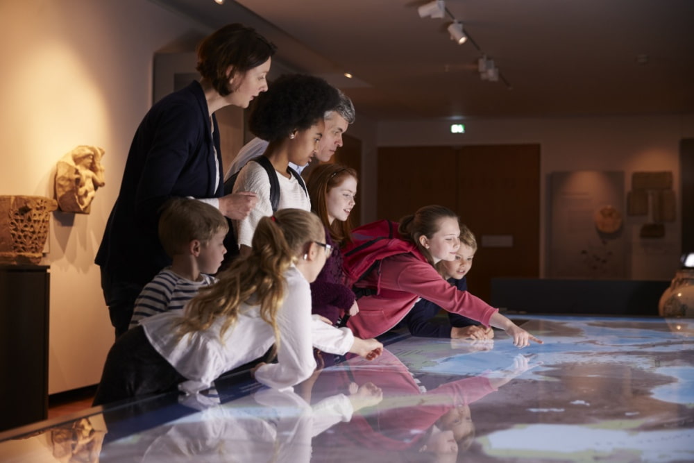 a group of children look at a museum exhibit on a school trip