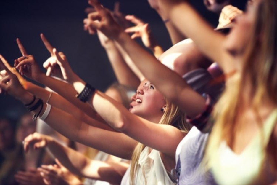 concert attendees raise their hands during a song