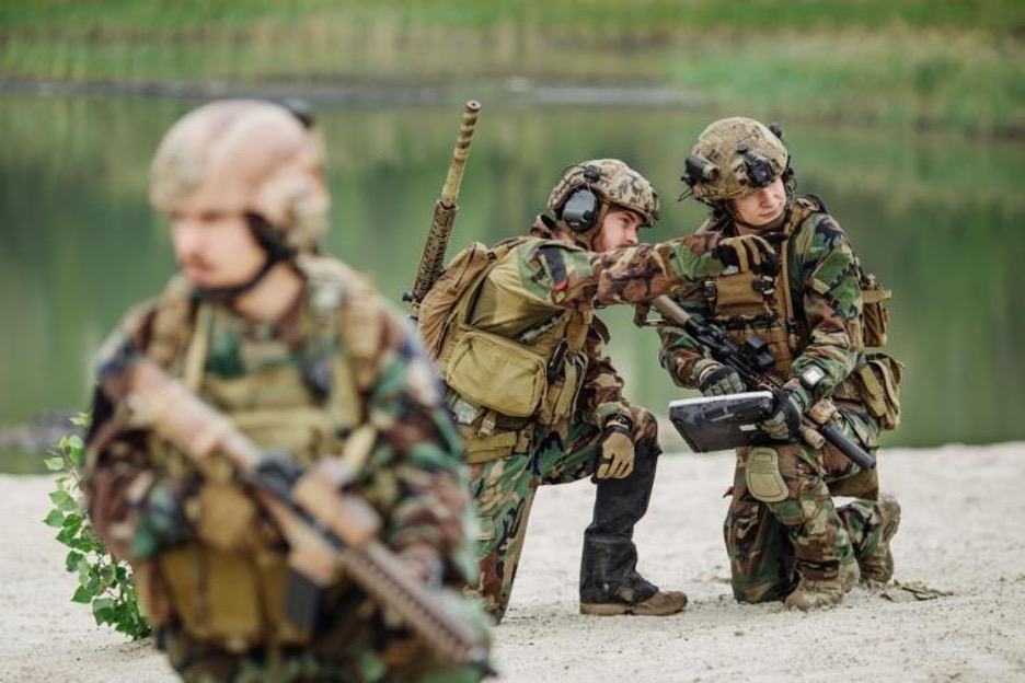 military personnel make a plan while dressed in full camo gear