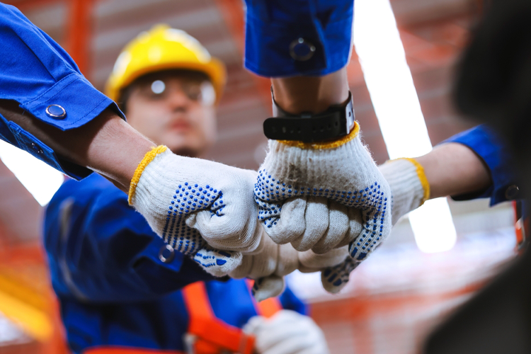 hands together at a construction site