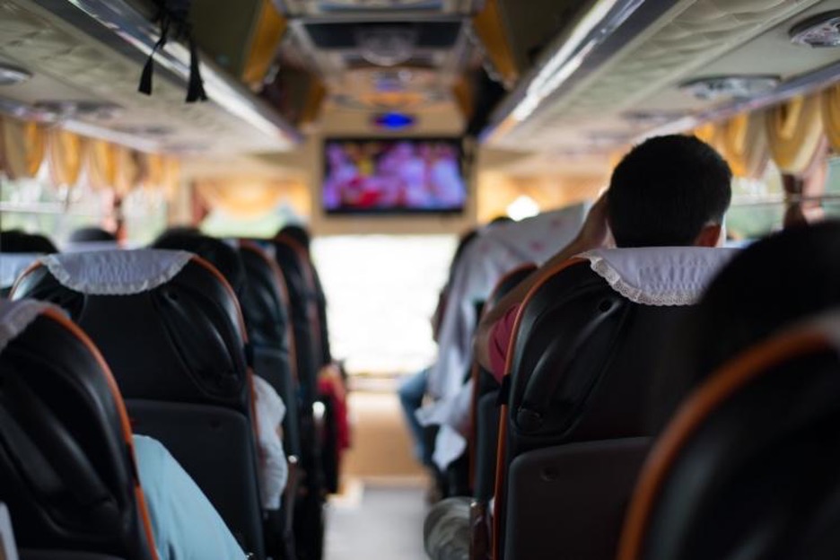 Passengers on a comfortable, dimly lit charter bus
