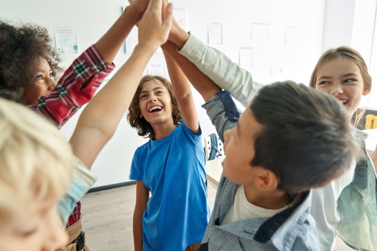 a group of kids smile and high-five