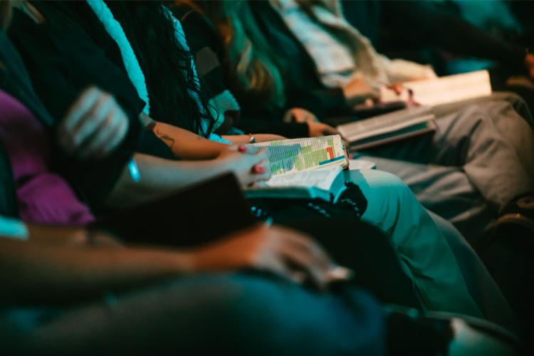 a group of adults sitting with bibles in their laps
