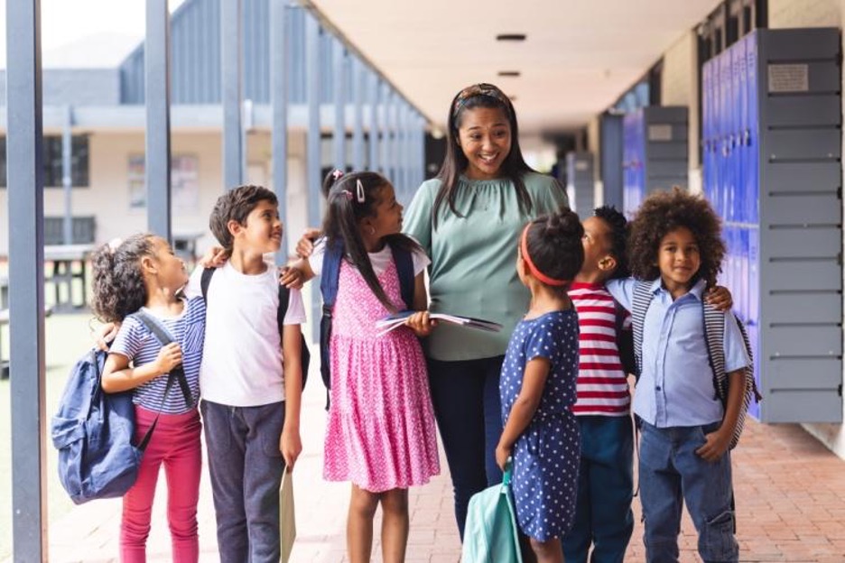 a student walks with students down an open hallway