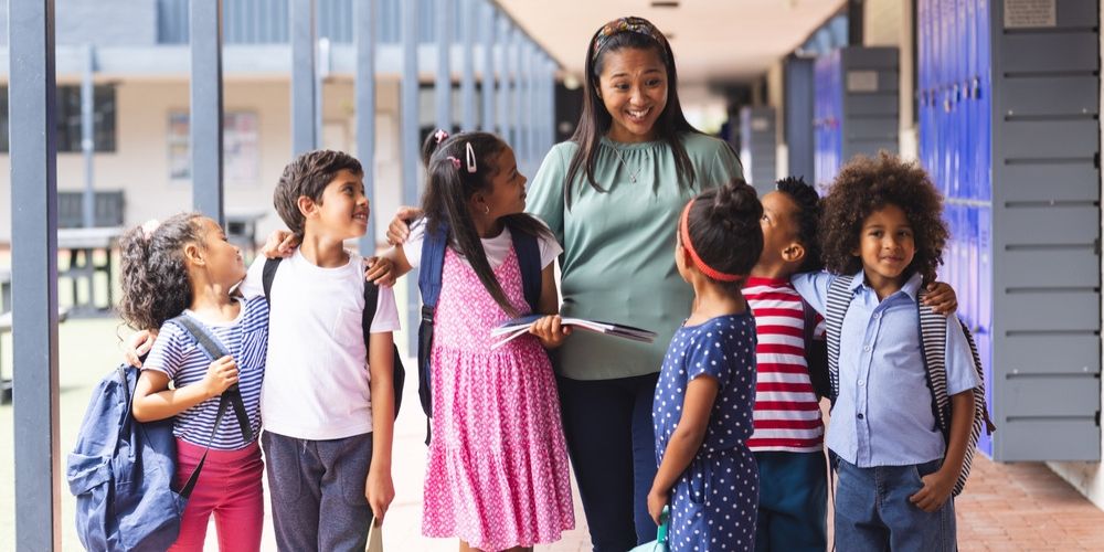 A teacher and her students laughing and talking