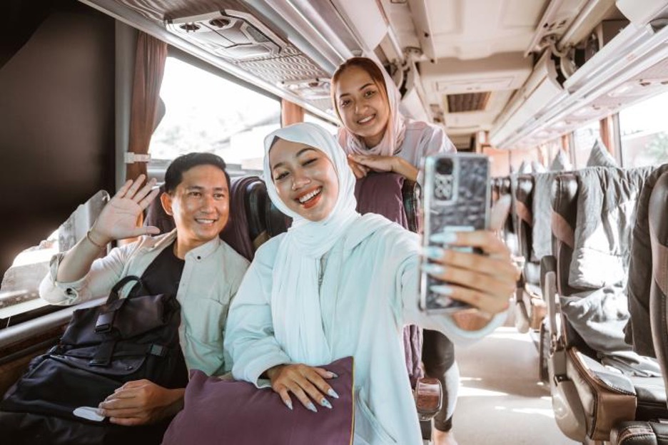 Travelers smile for a selfie on a charter bus