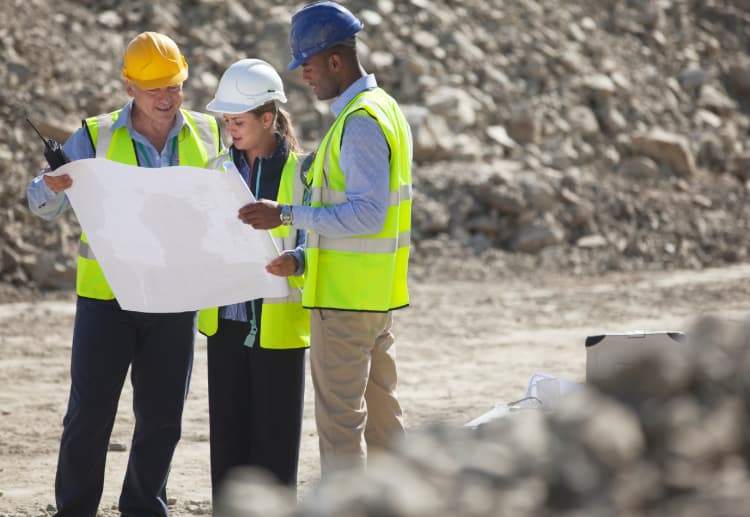 construction workers look at a site plan