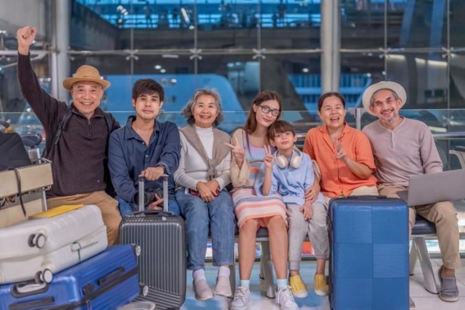 travelers arrive with suitcases to an airport