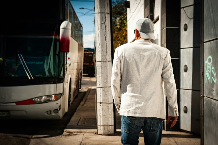 a passenger waits for a bus at a bus stop