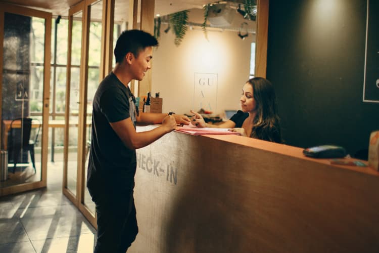 a man checks in to a cozy hotel