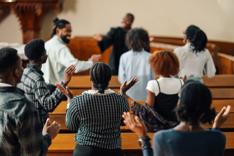 members of a church choir practice in the pews