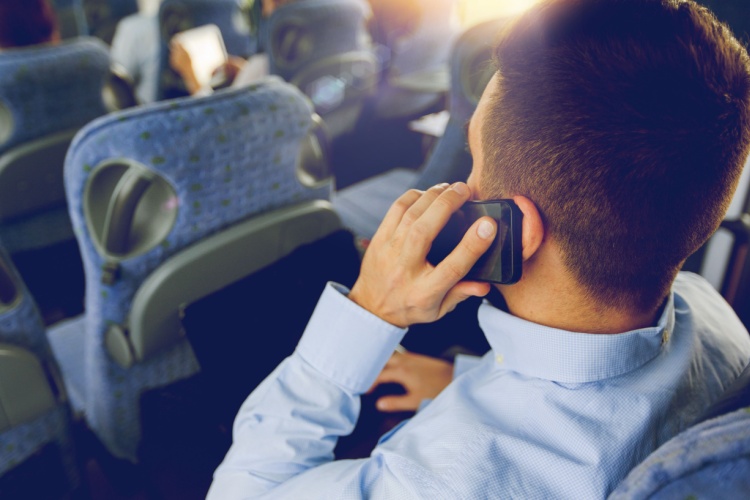 a man makes a call on his cellphone on a charter bus