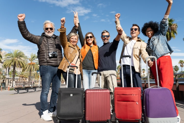 a group of travelers stand outside with their suitcases celebrating