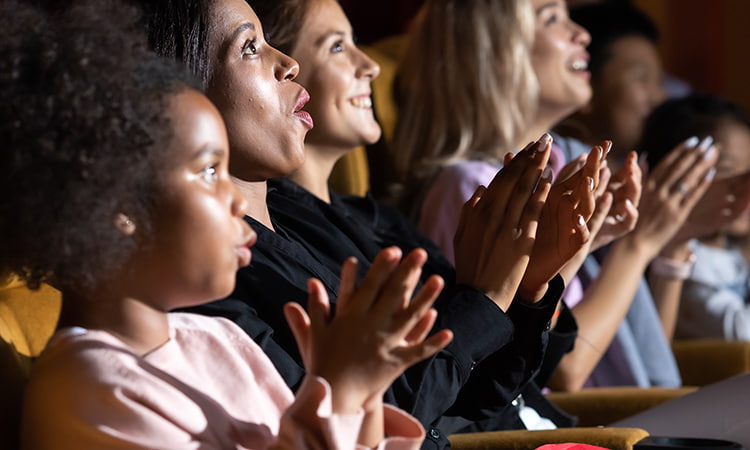 An audience applauds after a theatre performance